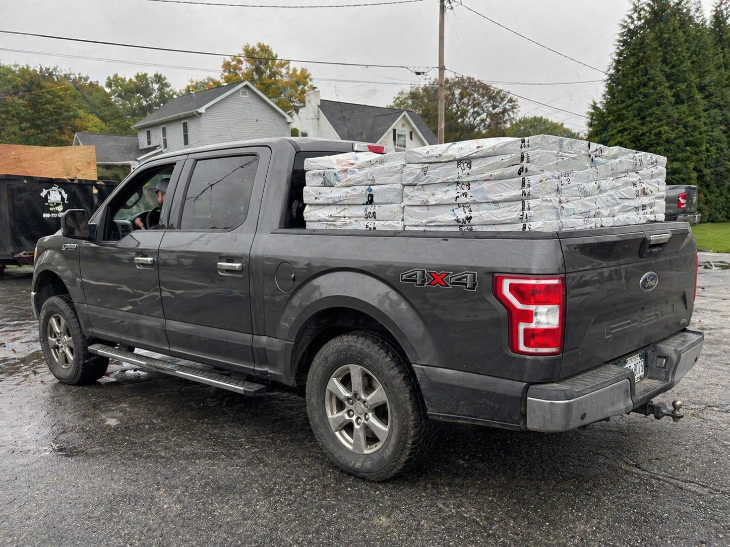 Contractor loading shingle bundles into a pickup truck